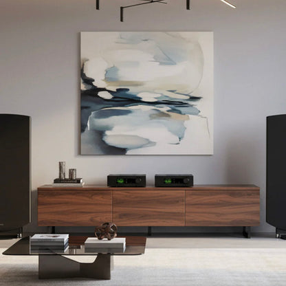 Modern living room with wooden entertainment console, abstract painting, and speakers.