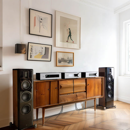 Wooden entertainment console with speakers in a room with framed art on the wall.