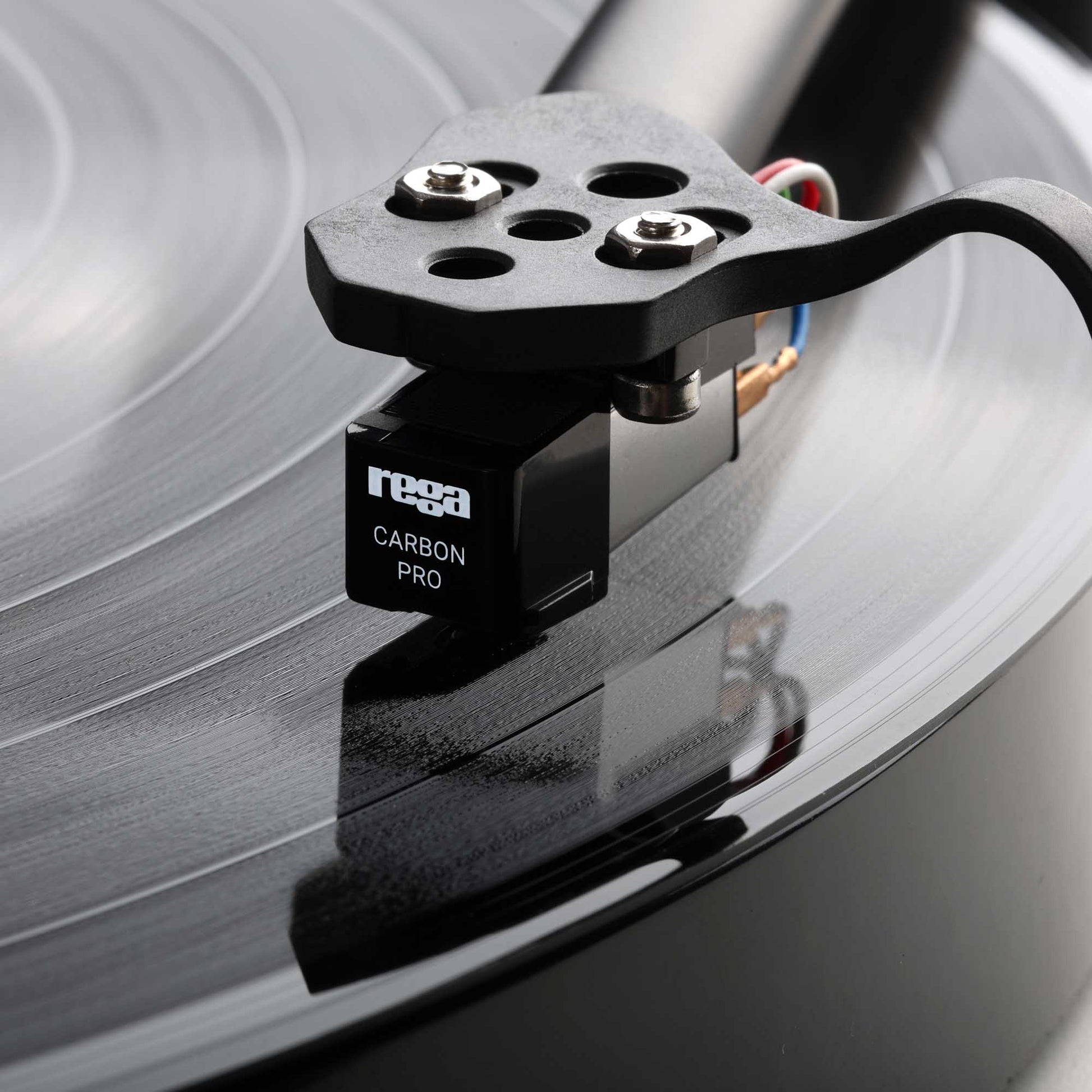 Turntable cartridge on a record with 'Rega' branding