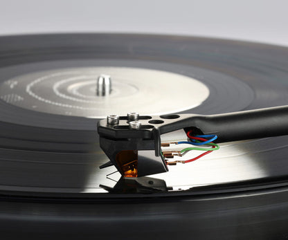 Close-up of a turntable needle on a vinyl record with a blurred background
