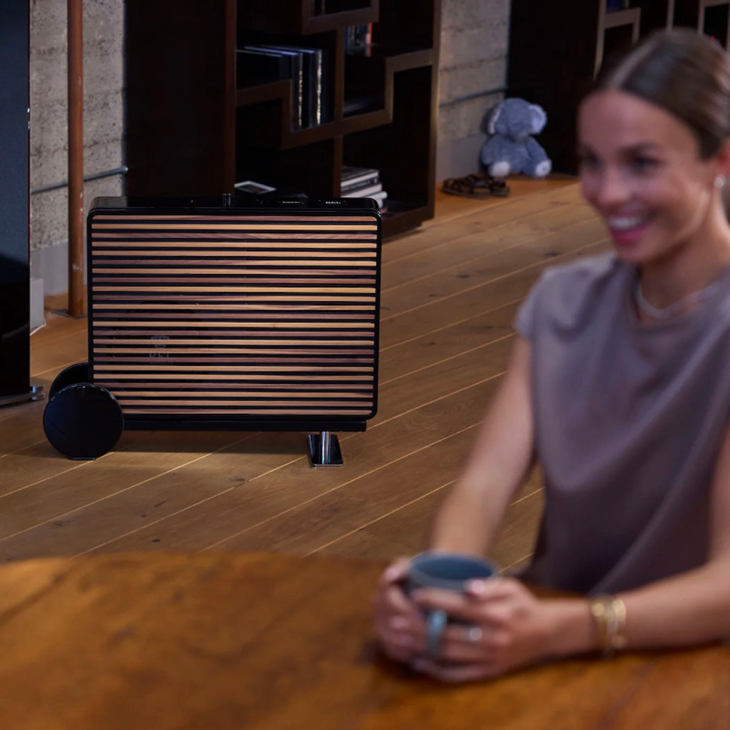 Woman holding a mug in a room with a black REL Planar PL-2 Powered Subwoofer in background