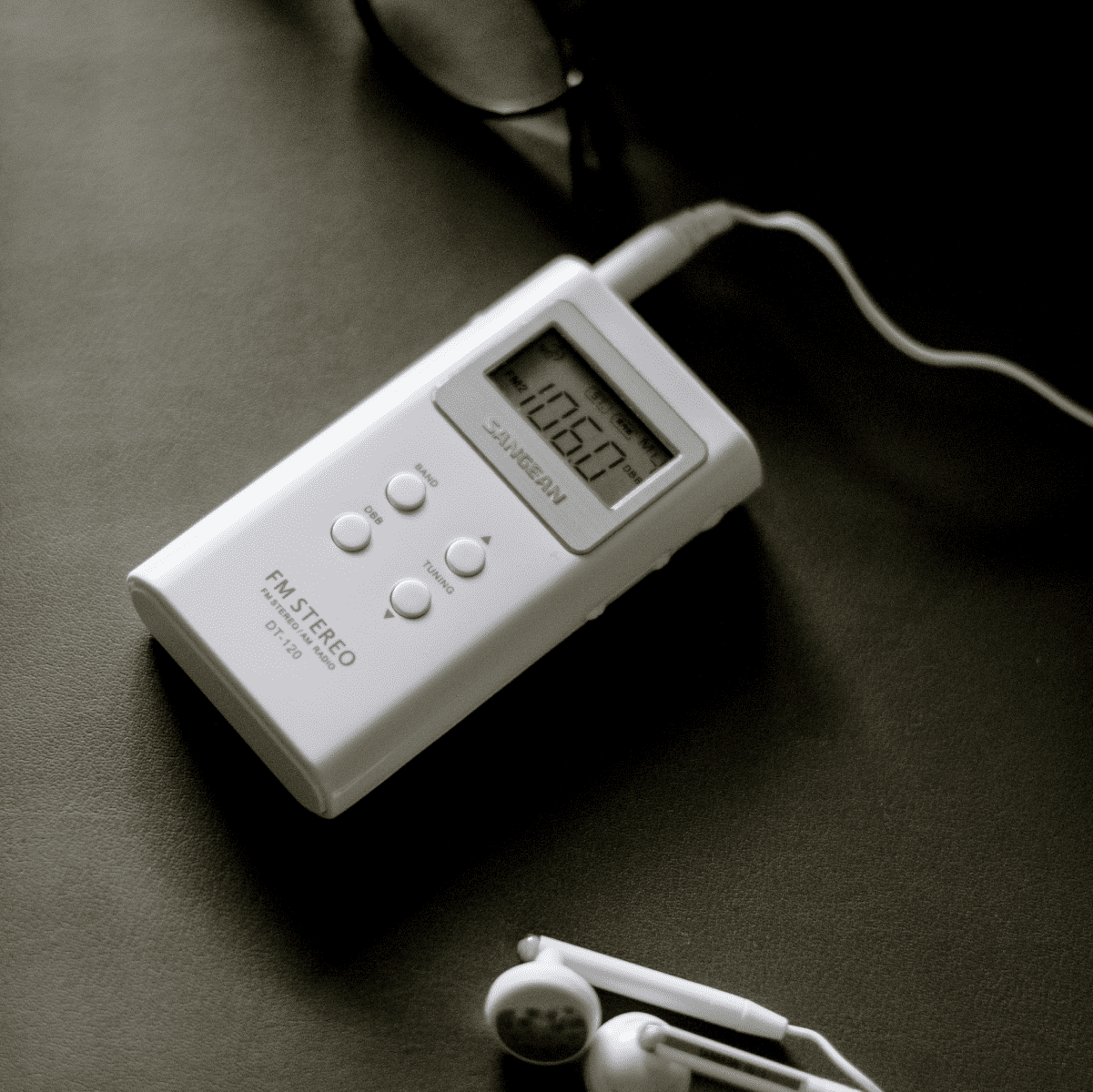 Sangean DT-120 AM/FM Stereo Pocket Radio with earbuds plugged in