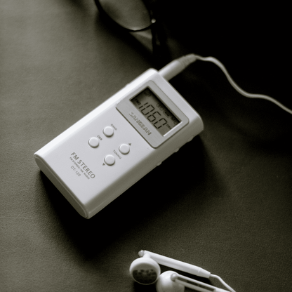 Sangean DT-120 AM/FM Stereo Pocket Radio with earbuds plugged in