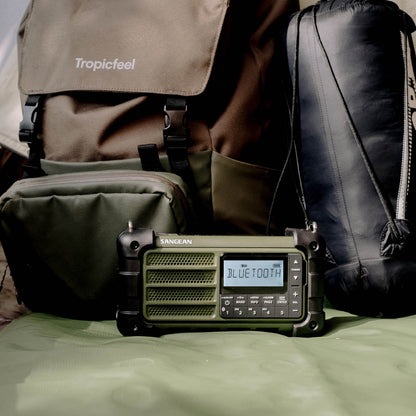 Portable radio with Bluetooth display on a surface with bags in the background