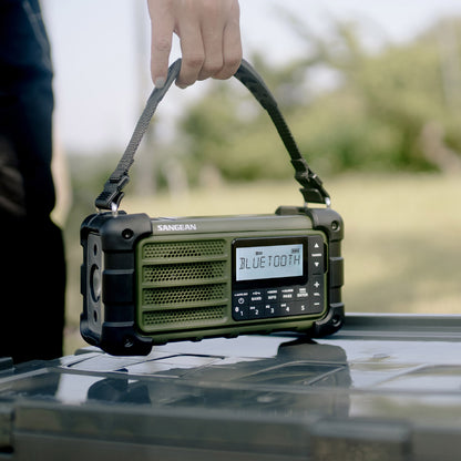 Green portable radio with Bluetooth indicator held by a person outdoors