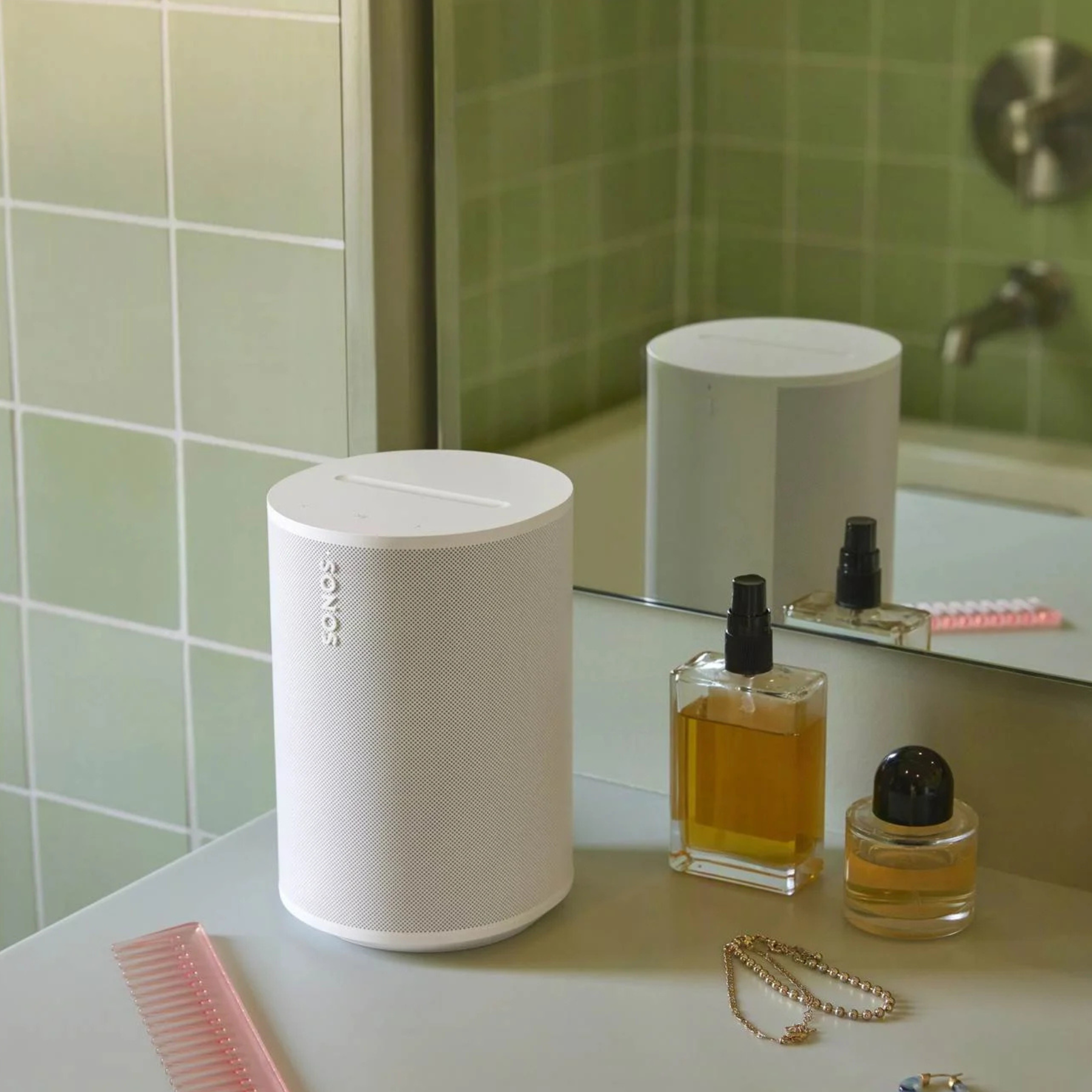 White Sonos ERA 100 on a bathroom counter with a mirror and toiletries in the background