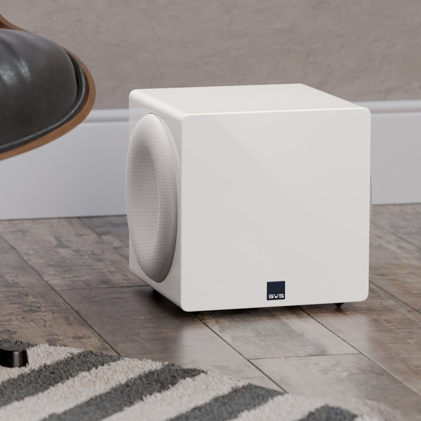 White subwoofer on a wooden floor with a neutral background