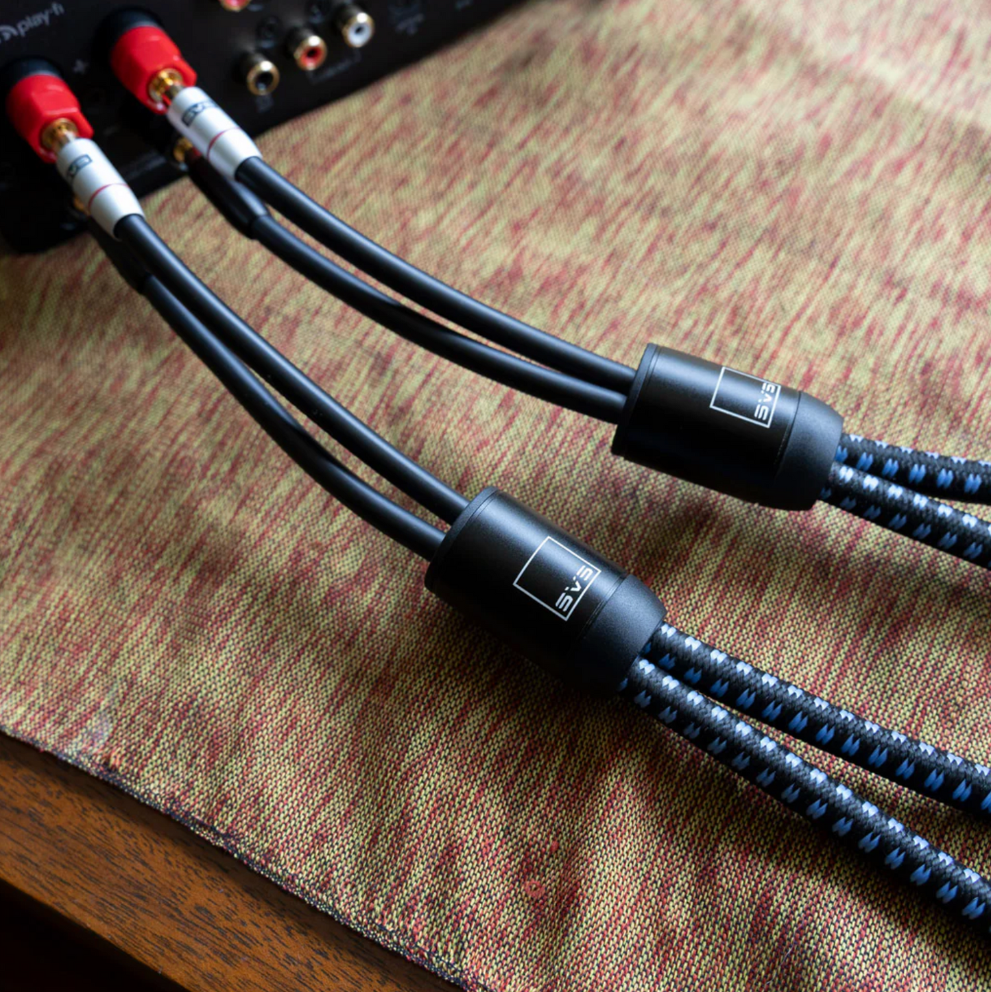 Three audio cables with braided design on a textured surface