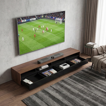 A modern wall-mounted TV stand in a living room setting, featuring a wood-grain top and open storage drawers. 