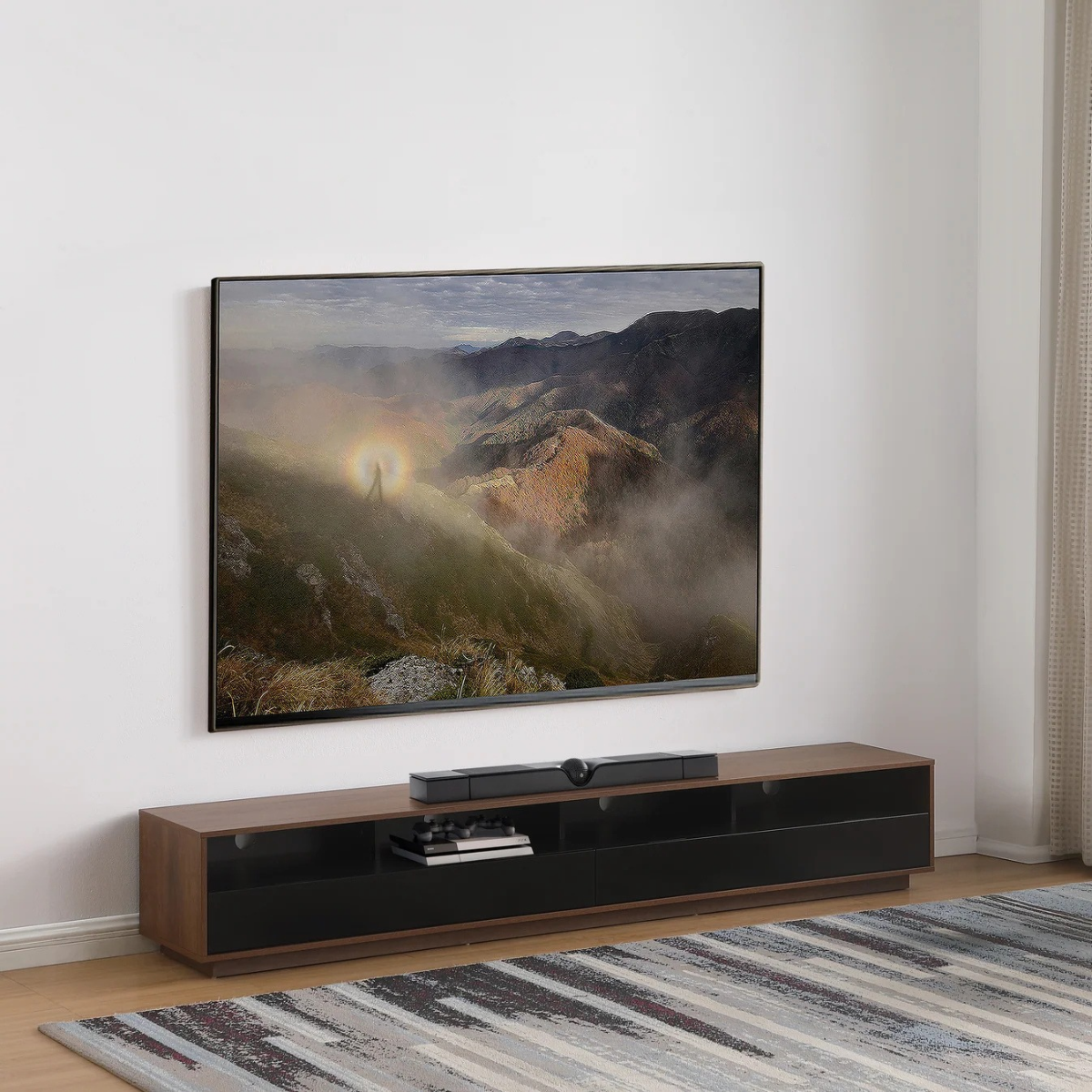 Modern TV stand with a large screen displaying a mountain scene in a room with a rug.