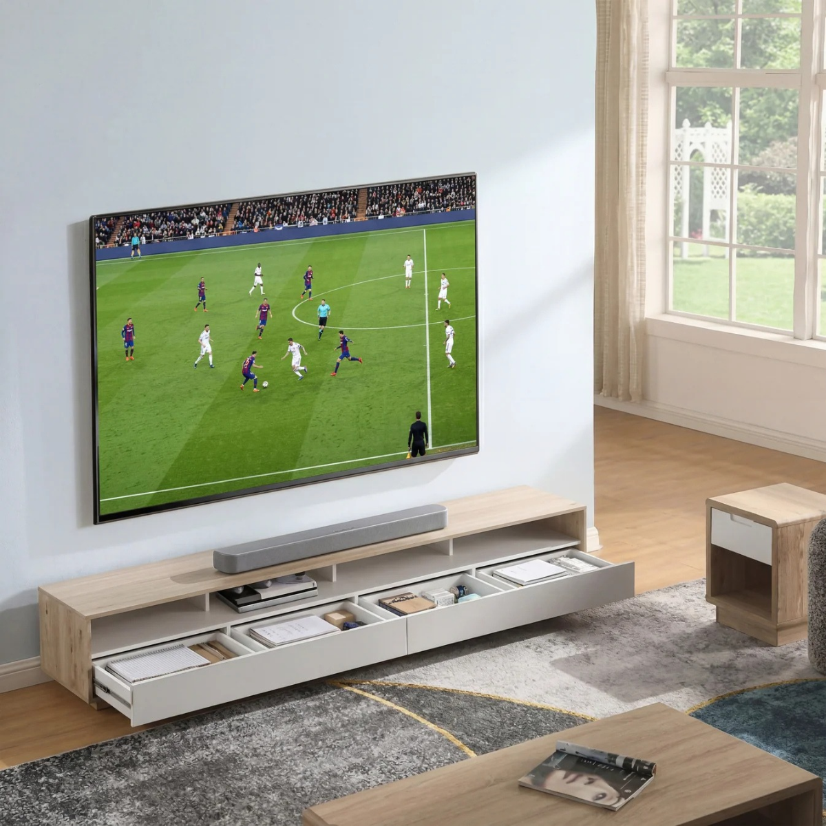 Living room with a large TV displaying a soccer game, soundbar below, and wooden furniture.