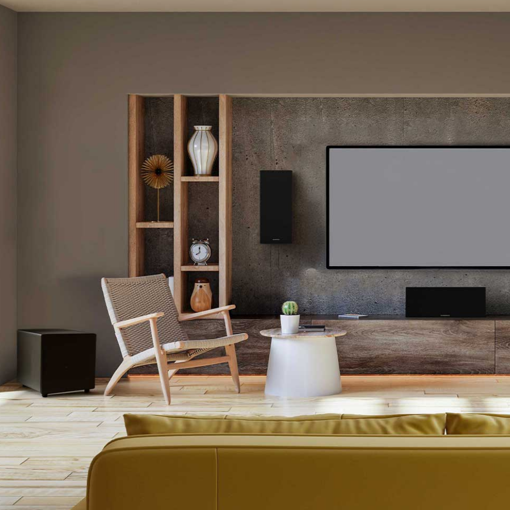 A modern living room interior with a large wall-mounted TV screen, open wooden shelving, a woven armchair, a small white side table, and a mustard yellow sofa in the foreground.