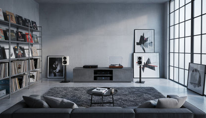 Modern living room with gray sofa, bookshelf, wall art and Wharfedale Diamond 12.1i Speakers