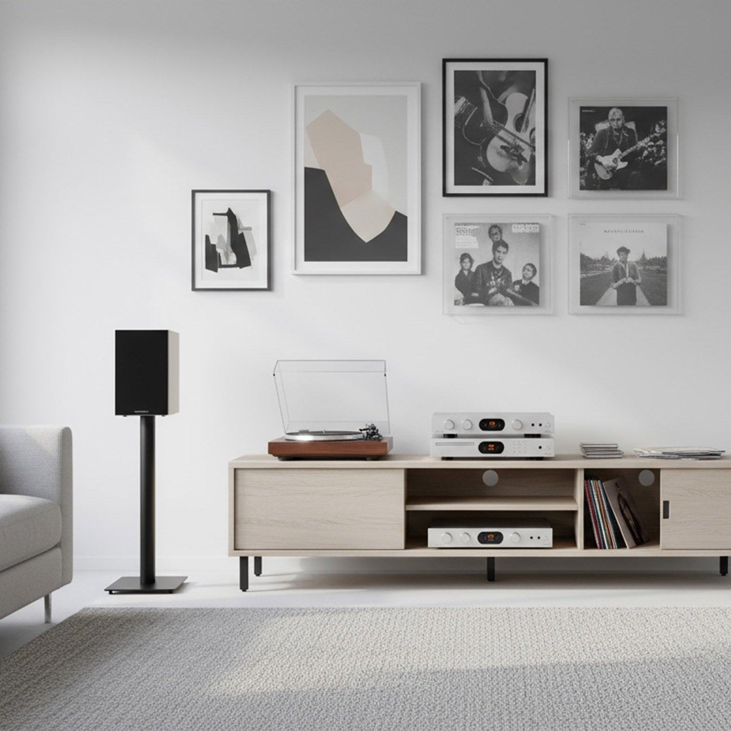 Modern living room with a wooden entertainment console, speakers, and framed pictures on the wall.