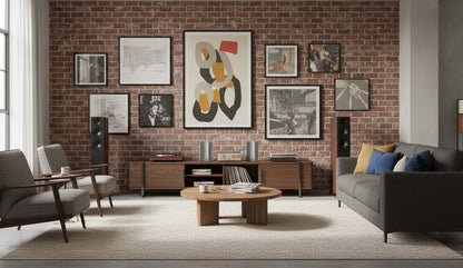 Modern living room with brick wall, gray sofa, and round wooden coffee table.