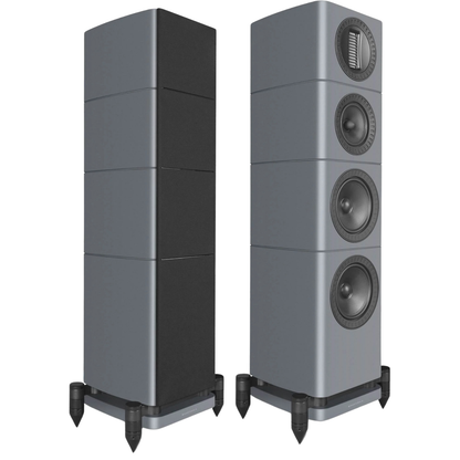 Two tall floorstanding speakers shown on a plain white background, one in a three-quarter rear view and one in a front three-quarter view showing the four driver cones.