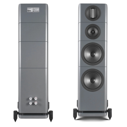 A pair of floorstanding speakers shown from the front and back against a white background. The speakers feature a metallic gray finish with black accents on the driver cones, stands, and terminal caps.