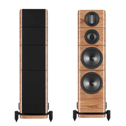 Two floorstanding speakers shown on a white background, one front view with grille on an one without. The speakers feature a light natural wood grain cabinet with black speaker cones and a black grille