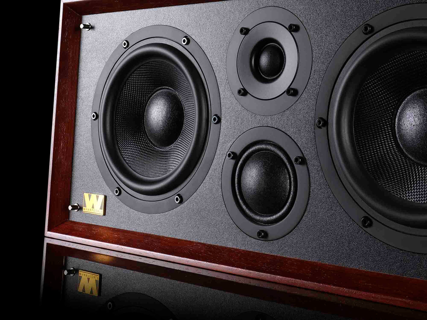 Close-up of a speaker with wooden frame and gray grille
