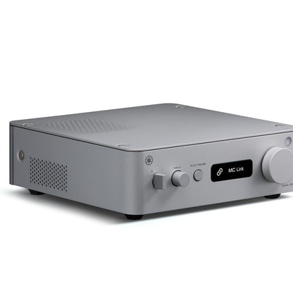 A silver audio receiver or amplifier with a matte finish, featuring a small black display screen showing 'MC Link' and physical knobs on the front, set against a plain white background.
