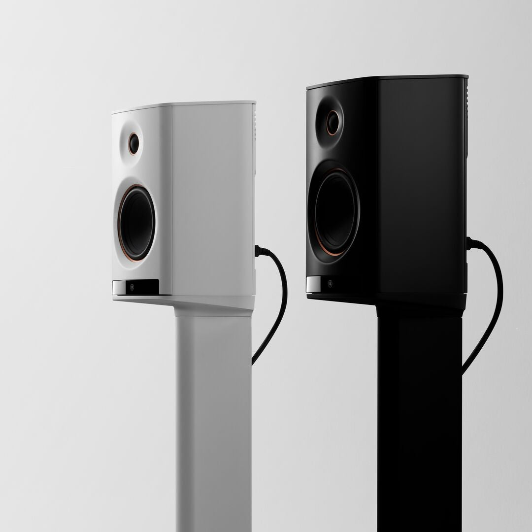 Two speakers, one white and one black, on a light gray background