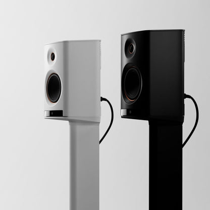 Two speakers, one white and one black, on a light gray background