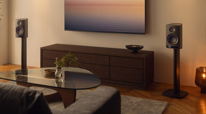 Living room with a television, speakers, and a coffee table.