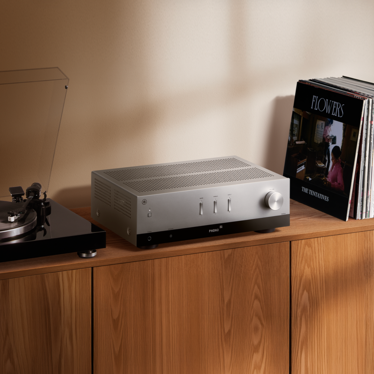 A silver Yamaha R200A Stereo Receiver on a wooden console